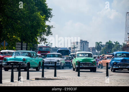 Vintage vecchie automobili americane utilizzati come taxi costituiscono la maggior parte del traffico che attraversa il Parque Central sulla trafficata Prado in Havana Cuba. Foto Stock