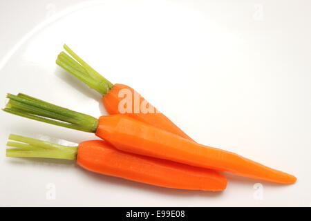 La fresca baby carota su sfondo bianco. Foto Stock