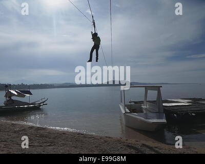 Sablayan, Filippine. 22 ottobre, 2014. Sablayan inaugura la sua isola in isola zipline che si estende fino a 1.7 chilometri dal Sablayan corretto come il salto-punto spento per Pulong Maliit come zona di atterraggio del turista e cercatori di avventura che mi piacerebbe provare questa zipline più lungo in Asia. Il paesaggio mozzafiato di chiare acque cristalline di Sablayan è visto lungo il tragitto: starfish e ricche formazioni coralline sono visibili mentre sulla zip. Sablayan è famosa per Apo Reef e Pandan Island che sono famosi per le immersioni. © Sherbien Dacalanio / Alamy Live News Foto Stock