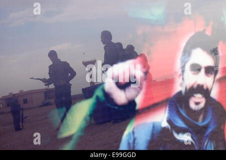 Unità di protezione del popolo curdo i combattenti YPG si riflettono in un vetro figura dell'ex leader militante del PKK Abdullah Ocalan durante un Cerimonia di reclutamento in un campo di addestramento ad al Hasakah o. Distretto di Hassakeh conosciuto come Rojava il de facto curdo autonomo regione originaria e costituita da tre cantoni autonomi in Siria settentrionale Foto Stock