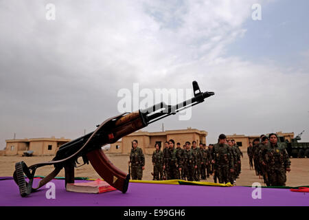 Un fucile Kalashnikov ak-47 posto su un tavolo durante il giuramento Cerimonia dei combattenti curdi delle unità di protezione delle donne YPJ In un campo di addestramento in al Hasakah o distretto di Hassakeh Nel nord della Siria Foto Stock