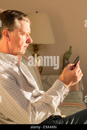 Senior uomo la lettura di eBook sul lettino Foto Stock