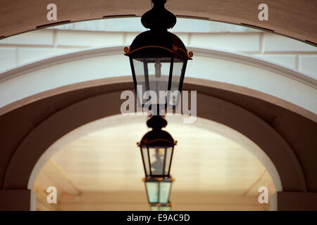 Una chiusura del vecchio stile luci lanterna appesa al di fuori di passaggi pedonali del vecchio collegio navale di Greenwich, Londra. Foto Stock