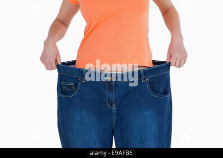 Slim donna che mostra quanto peso ha perso Foto Stock