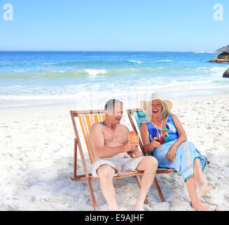 Coppia senior seduti su sedie a sdraio Foto Stock