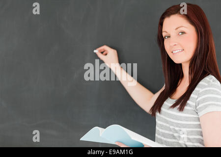 Felice giovane donna di scrittura su una lavagna Foto Stock