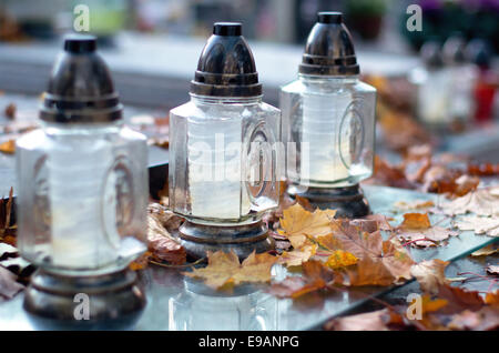 Cimitero di autunno, candele e caduta foglie. Foto Stock