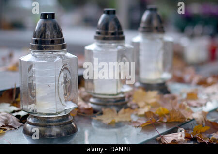 Cimitero di autunno, candele e caduta foglie. Foto Stock