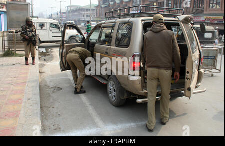 Srinagar, Indiano Kashmir amministrato. 23 ottobre, 2014. Un poliziotto indiano controlla i passeggeri veicoli durante un giorno di sciopero come negozi e imprese è rimasta chiusa nel Kashmir a causa di un separatista sponsorizzato sciopero per protestare per una visita alla regione da parte del Primo Ministro Narendra Modi Credito: Sofi Suhail/Alamy Live News Foto Stock