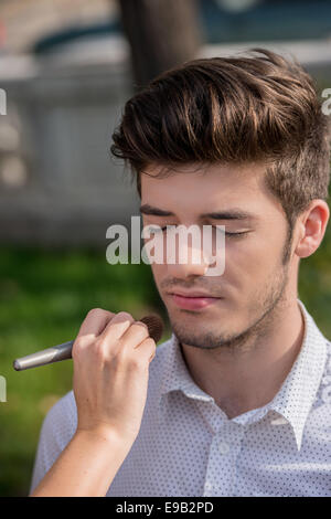 Bel giovane durante una sessione di trucco Foto Stock