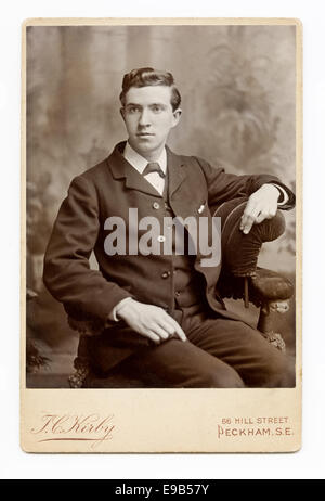 Armadio vittoriano Card studio ritratto di un giovane uomo in una tuta, seduta. Da TC Kirby di Peckham, Londra. Prese circa 1880 Foto Stock