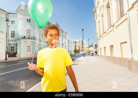 Felice ragazzo africano in giallo T-shirt con palloncino Foto Stock