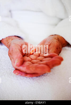 Senior persona con le mani in mano azienda Lipantil Fenofibrato Colesterolo capsula di prescrizione farmaci - assistenza sociale. Foto Stock