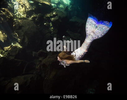 Mermaid con una coda incandescente nuotare nelle acque della penisola dello Yucatan, KuKulKan Cenote, QRoo, Messico Foto Stock