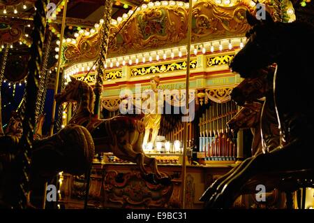Giostra a vapore di notte con i cavalli in giro di fronte illuminata luminosamente organo a canne Foto Stock