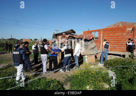 Buenos Aires, Argentina. 23 ott 2014. Poliziotti di detenere una persona durante un anti-droga il funzionamento a Los Paraguayos villaggio nei pressi di Quilmes Città, nello stato di Buenos Aires, Argentina, il Ott 23, 2014. Poliziotti hanno arrestato cinque persone e sequestrate dosi di cocaina e marijuana durante il funzionamento, secondo la stampa locale. Credito: TELAM/Xinhua/Alamy Live News Foto Stock