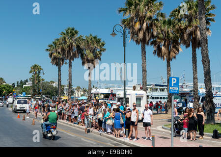 I turisti in attesa per il trasporto, la città di Kos, isola di Kos, Grecia Foto Stock