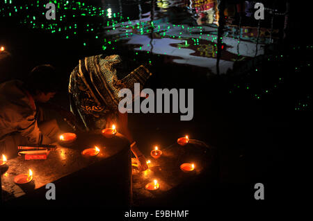 Dacca in Bangladesh. 23 ott 2014. Donna che prega alla Dea Kali con il fuoco. "Kali Puja' è un festival dedicato alla dea Indù Kali durante la luna nuova giornata nel mese indù. Maithili lo chiamano "hyama Puja' o Diwali. Credito: Mohammad Asad/Pacific Press/Alamy Live News Foto Stock