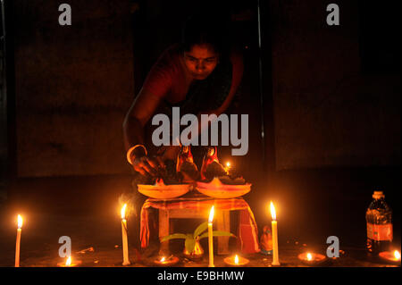 Dacca in Bangladesh. 23 ott 2014. Donna che prega alla Dea Kali con il fuoco. "Kali Puja' è un festival dedicato alla dea Indù Kali durante la luna nuova giornata nel mese indù. Maithili lo chiamano "hyama Puja' o Diwali. Credito: Mohammad Asad/Pacific Press/Alamy Live News Foto Stock