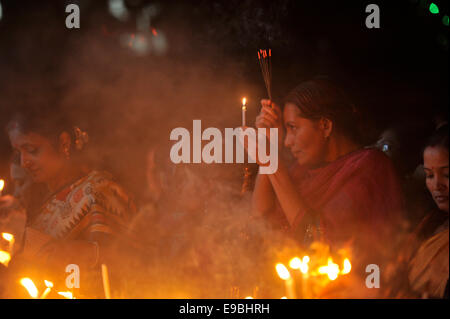 Dacca in Bangladesh. 23 ott 2014. Le donne pregare alla Dea Kali con il fuoco. "Kali Puja' è un festival dedicato alla dea Indù Kali durante la luna nuova giornata nel mese indù. Maithili lo chiamano "hyama Puja' o Diwali. Credito: Mohammad Asad/Pacific Press/Alamy Live News Foto Stock