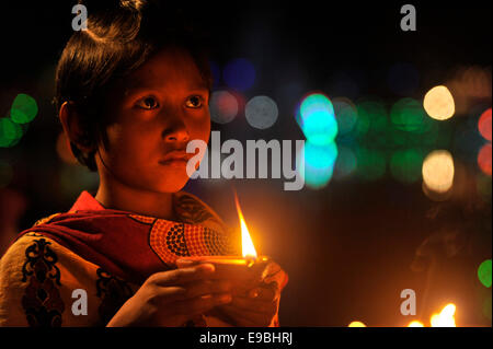 Dacca in Bangladesh. 23 ott 2014. Bambino prega alla Dea Kali con il fuoco. "Kali Puja' è un festival dedicato alla dea Indù Kali durante la luna nuova giornata nel mese indù. Maithili lo chiamano "hyama Puja' o Diwali. Credito: Mohammad Asad/Pacific Press/Alamy Live News Foto Stock