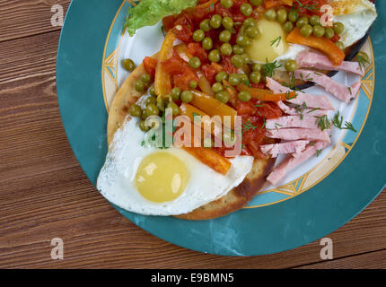 Huevos Motulenos - il cibo della colazione nella città di Motul (Yucatán) piatto è fatta con uova sulle tortillas , prosciutto, piselli, platani, Foto Stock