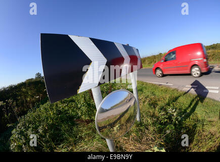 Van passando un cartello di segnalazione della curva circolare e specchio di sicurezza per dare piloti emergenti dalla vista svincolo stradale del Regno Unito Foto Stock