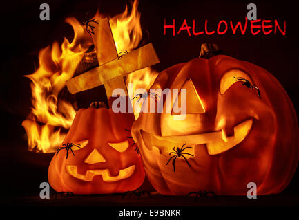 Scolpiti incandescente con zucca creepy ragni, luminoso fuoco ardente vicino a croce, scheda di invito per la festa di Halloween festa Foto Stock