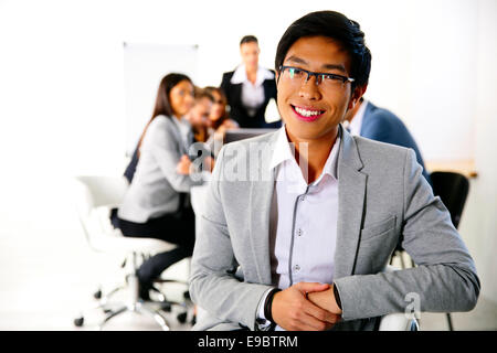 Imprenditore seduto sulla sedia da ufficio nella parte anteriore del business meeting Foto Stock