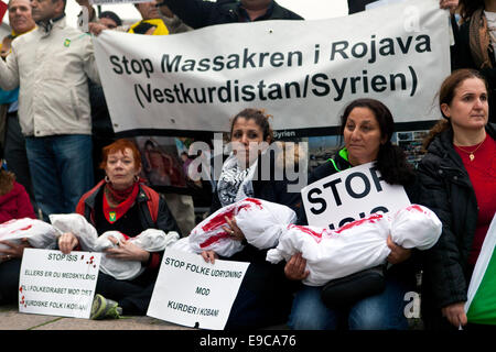 Copenhagen, Danimarca. 24 ott 2014. Donne curde seduta con sangue tinto body bags che simboleggiano i bambini morti in Kobani. Le donne sono illustrati in quanto essi possono partecipare a una dimostrazione di solidarietà al Parlamento europeo di Copenaghen in cui si chiede che essi esigono che la Turchia si apre la sua frontiera per i combattenti curdi e di soccorso in caso di emergenza al credito Kobani: OJPHOTOS/Alamy Live News Foto Stock