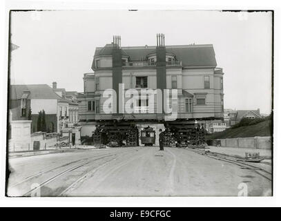 Questa immagine mostra una funivia che passa sotto l'ex residenza di Claus Spreckels, un importante uomo d'affari, in quanto viene trasferita da Herbert L. Hatch, noto come "The House Mover". La scena cattura un momento di storia architettonica a San Francisco. Foto Stock
