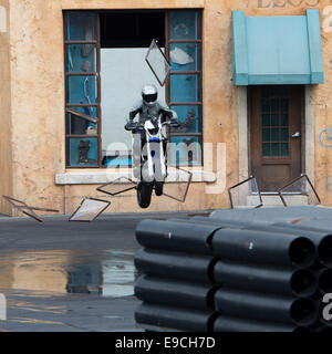 Il modo moto rider si rompe attraverso la finestra e i riquadri battenti, durante le luci, motori, azione! Extreme stunt show | Walt Disney Studios Foto Stock