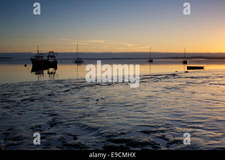 Swale estuario vicino a Faversham Kent REGNO UNITO. Il 25 ottobre 2014. Regno Unito Meteo: un chiaro, peperoncino sunrise e bassa marea a Swale estuario, Kent araldi una luminosa giornata soleggiata all'ultimo giorno del periodo estivo britannico (BST). Gli orologi andare indietro di un'ora di domenica a UTC/GMT Foto Stock