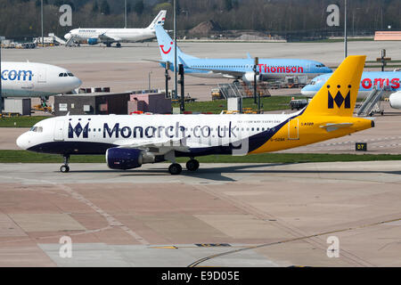 La Monarch Airlines Airbus A320 i taxi per la pista attiva all'aeroporto di Manchester. Foto Stock