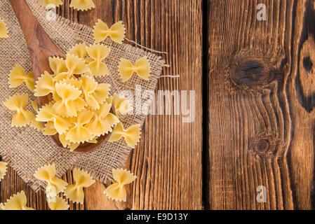 Farfalle (comunemente noto come pasta Bow-Tie) su un cucchiaio di legno Foto Stock