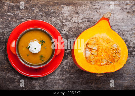 Zuppa di zucca e una metà hokkaido su legno Foto Stock