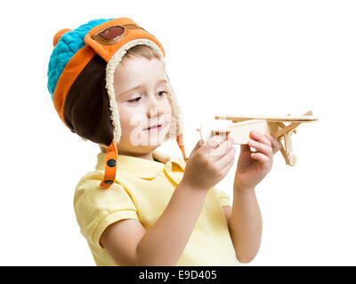 Kid boy vestito pilota guardando in legno giocattolo aereo Foto Stock