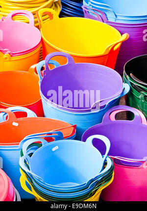 Selezione di plastica colorati vasi in un mercato Foto Stock