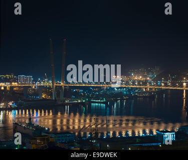 Vista notturna del ponte in russo Vladivostok su Golden Horn (Zolotoy Rog) Baia. Foto Stock
