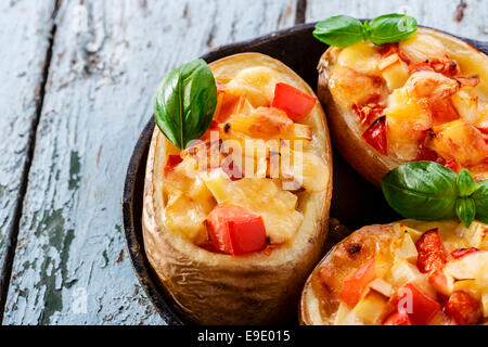 Patate ripiene con il formaggio e i pomodori in una padella Foto Stock