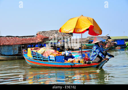 Donna vendere mercanzia con ombrellone in barca sul lago Tonle Sap, Cambogia, sud-est asiatico, in Indocina Foto Stock