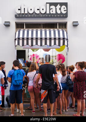 Gli adolescenti in attesa al fine di gelato nella parte anteriore del negozio di gelato al cioccolato. Malaga, Spagna. Foto Stock