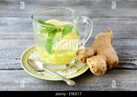 Il tè allo zenzero con menta e limone in un vetro, bibita salutare Foto Stock