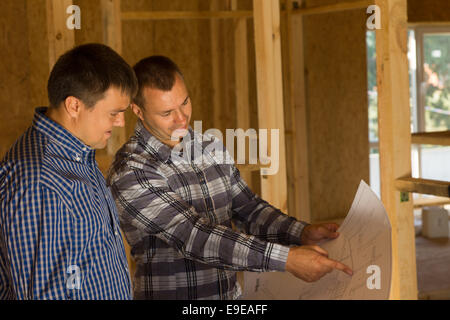 Bianco maschio professionale edificio Architetto e cliente per discutere l'Interior Design Edilizia sulla stampa di blu. Foto Stock
