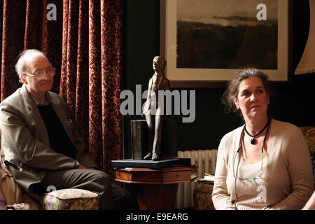 Swansea, Regno Unito. Sabato 25 ottobre 2014 nell'immagine: un Dylan Thomas statuetta tra Kirsten Jones (R) e un membro del suo pubblico nella camera anteriore di Dylan Thomas' luogo di nascita. Re: Dylan Thomas compleanno le celebrazioni del centenario presso il suo luogo di nascita, 5 unità Cwmdonkin, Swansea, Galles del Sud. Foto Stock