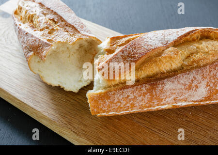 Crostini di fresca baguette francese su un tagliere di legno Foto Stock