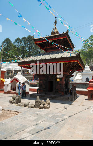 Tempio su ingresso sul ponte attraverso il sacro fiume Bagmati in Pashupatinath, Kathmandu Foto Stock