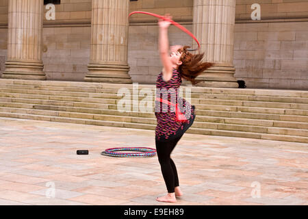 Claire Nicoll hula hoop dancing in un freddo e ventoso ottobre pomeriggio presso l'entrata frontale del Caird Hall di Dundee, Regno Unito Foto Stock