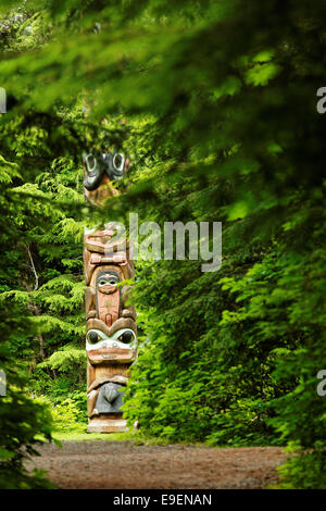 Base di K'alyaan pole visto giù il sentiero attraverso la foresta, Sitka National Historical Park, Sitka, Alaska, STATI UNITI D'AMERICA Foto Stock