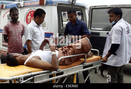 Assam, India. 26 ott 2014. Un infortunio per un passeggero di un autobus è portato in ospedale a Guwahati, capitale dell India nordorientale del stato di Assam il 26 ottobre, 2014. Nove persone sono state uccise e 26 altri feriti quando un bus di accelerazione ribaltata e cadde in un fosso stradale in Assam domenica, la polizia ha detto. Credito: Stringer/Xinhua/Alamy Live News Foto Stock